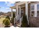 Charming brick home featuring a welcoming front porch with classic white columns and manicured landscaping at 2713 Tunstall Grove Dr, Apex, NC 27523