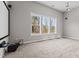 Spacious living room featuring three large windows, neutral walls, and plush carpeting, perfect for relaxation at 2713 Tunstall Grove Dr, Apex, NC 27523