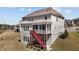 Backyard view of the home with a screened porch and stairs leading to the ground level at 2713 Tunstall Grove Dr, Apex, NC 27523