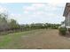 Open backyard with a black metal fence, view of neighborhood homes and trees at 288 Whispering Wind Dr, Chapel Hill, NC 27516