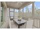 Relaxing screened porch with neutral decor, ceiling fan, and views of the lush greenery beyond at 288 Whispering Wind Dr, Chapel Hill, NC 27516
