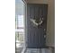 Inviting gray front door with a modern wreath, opening to a glimpse of the home's interior at 2915 Cox Mill Rd, Sanford, NC 27332