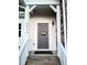 Stylish gray front door adorned with a floral wreath, complemented by white trim and brick accents at 2915 Cox Mill Rd, Sanford, NC 27332