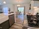 Modern kitchen with stainless steel gas range and quartz countertops, open to the dining area at 2915 Cox Mill Rd, Sanford, NC 27332