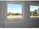 The open field view is framed by white trim windows at 2915 Cox Mill Rd, Sanford, NC 27332