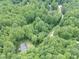 Aerial view of a house nestled among lush green trees, showcasing its secluded and peaceful setting at 3014 Split Wood Ct, Oxford, NC 27565