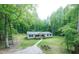 Inviting single-story home featuring a cozy front porch and a stone path surrounded by trees at 3014 Split Wood Ct, Oxford, NC 27565
