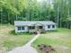 Charming single-story home boasts a welcoming front porch and a well-maintained yard surrounded by lush trees at 3014 Split Wood Ct, Oxford, NC 27565