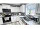 Bright kitchen showcasing stainless appliances, backsplash, stone countertops, and a large sink near a window at 3014 Split Wood Ct, Oxford, NC 27565