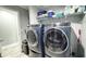 Updated laundry room with gray walls features new, front load washer and dryer and storage at 3014 Split Wood Ct, Oxford, NC 27565