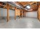 Unfinished basement with concrete floor, exposed wooden beams, and ample storage space at 302 Rushingwater Dr, Cary, NC 27513