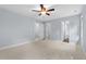 Spacious bedroom with ceiling fan and multiple doors to other rooms at 302 Rushingwater Dr, Cary, NC 27513