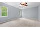 Spacious bedroom with large windows, ceiling fan, and neutral carpet at 302 Rushingwater Dr, Cary, NC 27513