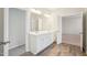 A bathroom featuring a double sink vanity, modern lighting, wood-look floors and adjacent access to other rooms at 3348 Table Mountain Pine Dr, Raleigh, NC 27616