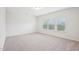 Bright bedroom with neutral carpet, three windows and white walls creates a serene and inviting space at 3348 Table Mountain Pine Dr, Raleigh, NC 27616