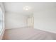 Spacious carpeted bedroom with a door to the hallway and natural light at 3348 Table Mountain Pine Dr, Raleigh, NC 27616