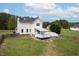 A white two-story home showcases a spacious backyard with a deck and fenced area, perfect for outdoor activities at 3690 Mabel Ln, Stem, NC 27581