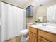 Bright bathroom features a shower with a curtain, a cabinet above the toilet, and a wooden vanity at 3690 Mabel Ln, Stem, NC 27581