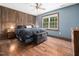 Bedroom with hardwood floors, natural light and wooden accent wall behind bed at 3690 Mabel Ln, Stem, NC 27581