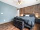 Bedroom with hardwood floors, wooden accent wall behind bed and natural lighting at 3690 Mabel Ln, Stem, NC 27581