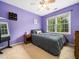 Bedroom with purple walls, double windows, and a full sized bed on carpeted floor at 3690 Mabel Ln, Stem, NC 27581