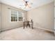 Well-lit bedroom featuring neutral walls, carpeted floors, a ceiling fan, and a quaint workspace at 3690 Mabel Ln, Stem, NC 27581