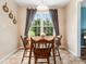 Cozy breakfast nook with a round wooden table and a window overlooking the backyard at 3690 Mabel Ln, Stem, NC 27581
