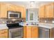 Modern kitchen with stainless steel appliances, light wood cabinets, and a bright, functional layout at 3690 Mabel Ln, Stem, NC 27581