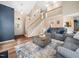 Open-concept living room featuring a staircase, lovely decor, and comfortable gray sofas at 3690 Mabel Ln, Stem, NC 27581
