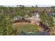 Backyard aerial view of a grassy backyard with a playground set nestled among mature trees at 381 Heart Pine Dr, Wendell, NC 27591