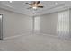 Bright bedroom with a ceiling fan, neutral carpet, and large windows with curtains at 381 Heart Pine Dr, Wendell, NC 27591
