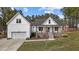 Charming two-story home boasts a light blue front door, covered porch and a manicured lawn at 381 Heart Pine Dr, Wendell, NC 27591