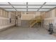 Spacious garage featuring ample storage space and a wooden staircase to an upper level at 381 Heart Pine Dr, Wendell, NC 27591