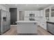 Kitchen with white cabinets, stainless steel appliances, a large island and a modern design at 381 Heart Pine Dr, Wendell, NC 27591
