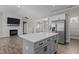 Open concept kitchen with white cabinets, stainless steel appliances, and island flows into living room at 381 Heart Pine Dr, Wendell, NC 27591