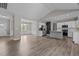 Open-concept living space with hardwood floors, white cabinets, and stainless steel appliances at 381 Heart Pine Dr, Wendell, NC 27591