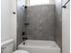 Modern bathroom with gray tiled shower-tub, rainfall showerhead and sleek fixtures at 3908 Sage Ct, Wake Forest, NC 27587