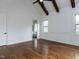 Elegant bedroom featuring hardwood floors, custom trim, and a view into the ensuite bathroom at 3908 Sage Ct, Wake Forest, NC 27587