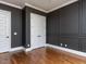 Sophisticated bedroom with dark accent wall, white trim, hardwood floors and double doors at 3908 Sage Ct, Wake Forest, NC 27587