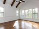 Sun-drenched bedroom boasts hardwood floors, large windows, and vaulted ceiling with wood beams at 3908 Sage Ct, Wake Forest, NC 27587