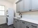 This laundry room features gray cabinets, white countertops, a sink, and a stacked washer and dryer at 3908 Sage Ct, Wake Forest, NC 27587