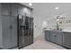 Contemporary kitchen with stainless steel refrigerator and gray cabinets, flowing into the living area at 40 Hill Rd, Franklinton, NC 27525