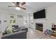 Inviting living room with a fireplace, mounted TV, ceiling fan, and a comfortable sectional sofa with throw pillows at 40 Hill Rd, Franklinton, NC 27525