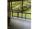 Enclosed porch features wooden floors, railings, and views of the lush backyard at 4001 W Antioch Dr, Oxford, NC 27565