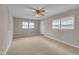 Bright bedroom features neutral walls, a ceiling fan, carpeting, and multiple windows at 407 W Cornwall Rd, Cary, NC 27511