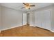 Bedroom with wood floors, a ceiling fan, and a double-door closet for ample storage at 407 W Cornwall Rd, Cary, NC 27511