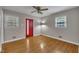 Bedroom with hardwood floors, a bright red exterior door and two windows with natural light at 407 W Cornwall Rd, Cary, NC 27511