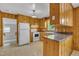 Functional kitchen featuring knotty pine cabinets, white appliances, and easy-to-clean flooring at 407 W Cornwall Rd, Cary, NC 27511