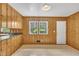 Wood-paneled room showcasing a window, door and views into the eat-in kitchen space at 407 W Cornwall Rd, Cary, NC 27511