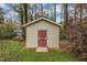 Storage shed with red door and a small concrete pad at 407 W Cornwall Rd, Cary, NC 27511